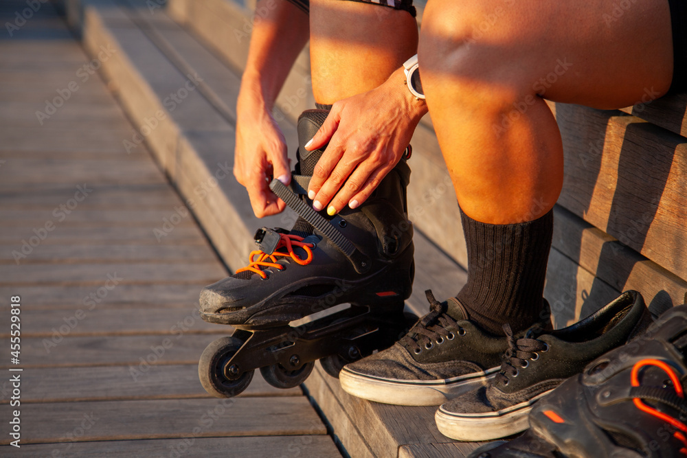 Mujer con accesorios de roller. Botas de patinaje en línea. Piernas de mujer con los patines puestos. Mujer con accesorios de roller. Botas de patinaje en línea. Piernas de mujer con los patines puestos.