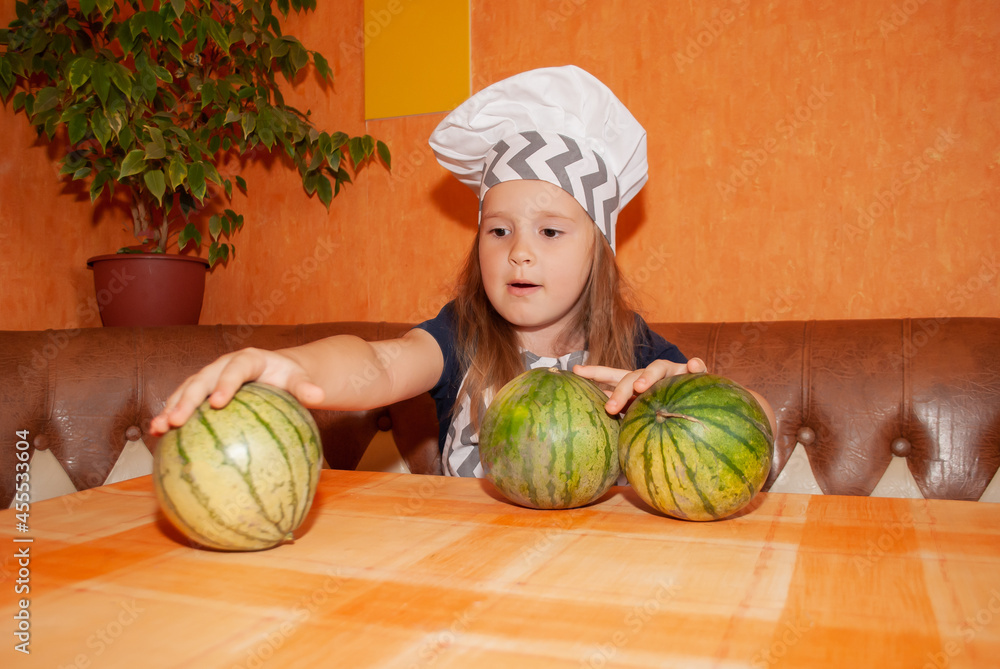 Fototapeta premium harvest day, cook's day, a girl in a cook's cap with arbks on the table canns blanks for the winter