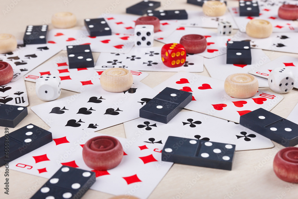 Wooden checkers, playing cards, dominoes and dice for board games on table close up. Wooden checkers, playing cards, dominoes and dice for board games on table close up.