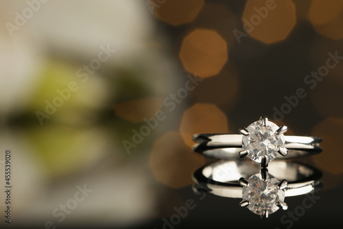 Beautiful engagement ring against blurred festive lights, closeup. Space for text © New Africa