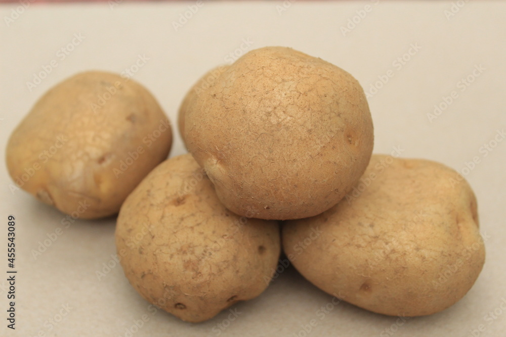 Pile 4 raw potatoes on the table