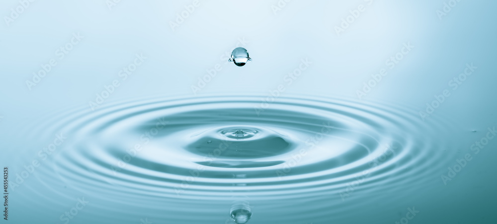 Splash of water droplets on a smooth water surface Splash of water droplets on a smooth water surface