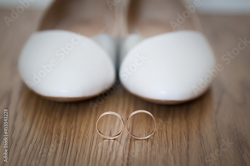 Bridal accessories for wedding day. Wedding rings on white shoes.