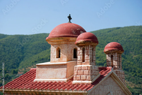 Little greek church building with mountains in background