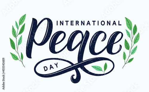 International Peace Day typography poster. Modern brush calligraphy day of peace decorated by green branches. Stylish design as template for card, postcard, banner, poster. 