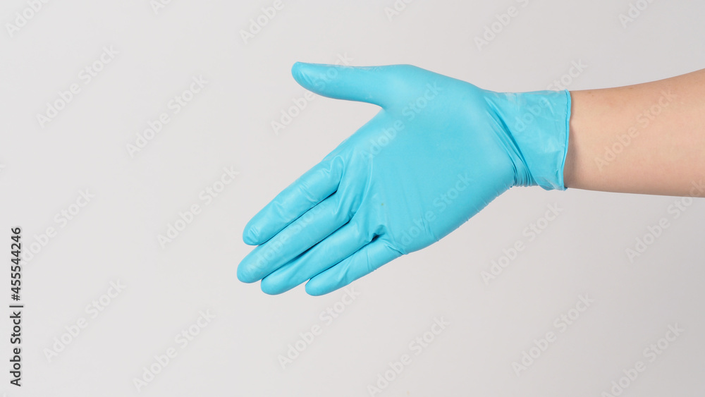Handshake gesture wearing blue medical glove on white background.