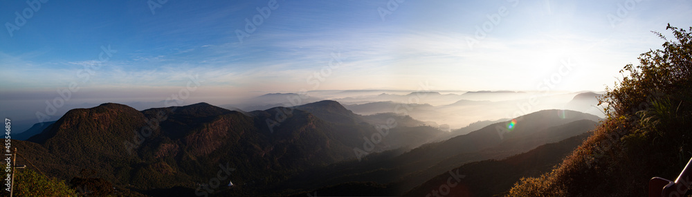 Sunrise panorama in the mountains with clouds and fog.