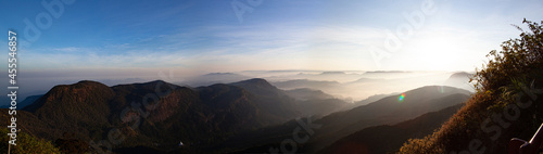 Sunrise panorama in the mountains with clouds and fog.