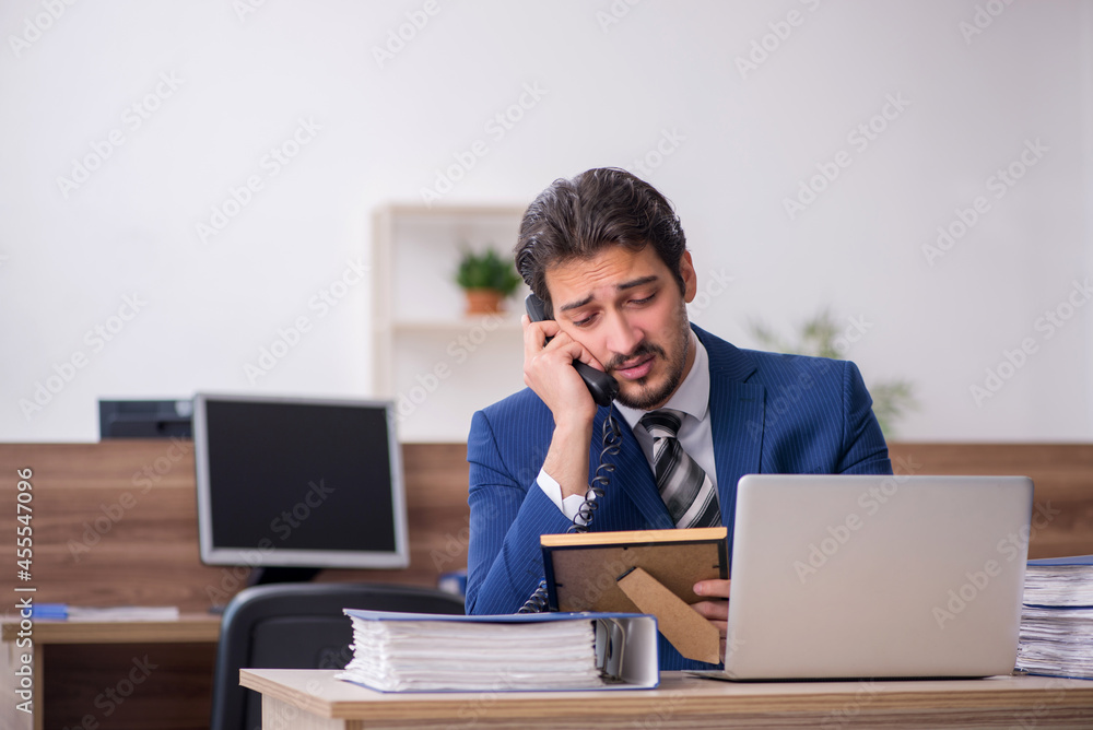Young male employee missing girlfriend at workplace Young male employee missing girlfriend at workplace