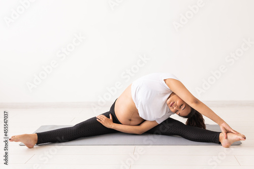 Healthy pregnant woman doing gymnastic at home. Pregnancy, healthy lifestyle and maternity leave