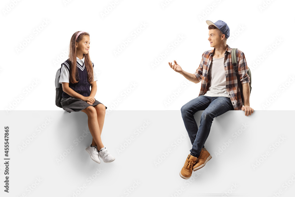 Schoolgirl and a teenager seated on a panel having a conversation Schoolgirl and a teenager seated on a panel having a conversation