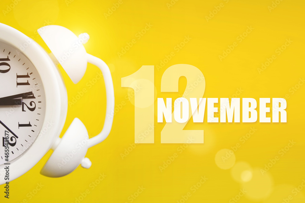 November 12nd. Day 12 of month, Calendar date. White alarm clock on yellow  background with calendar day. Autumn month, day of the year concept. Stock  Photo