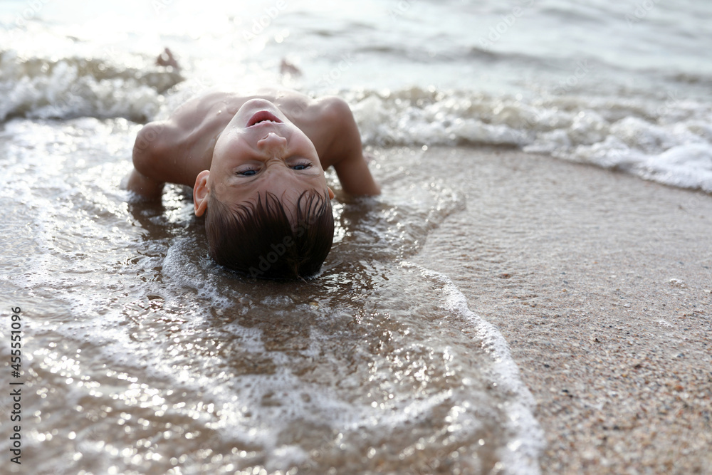 Boy lying on beach of Azov sea