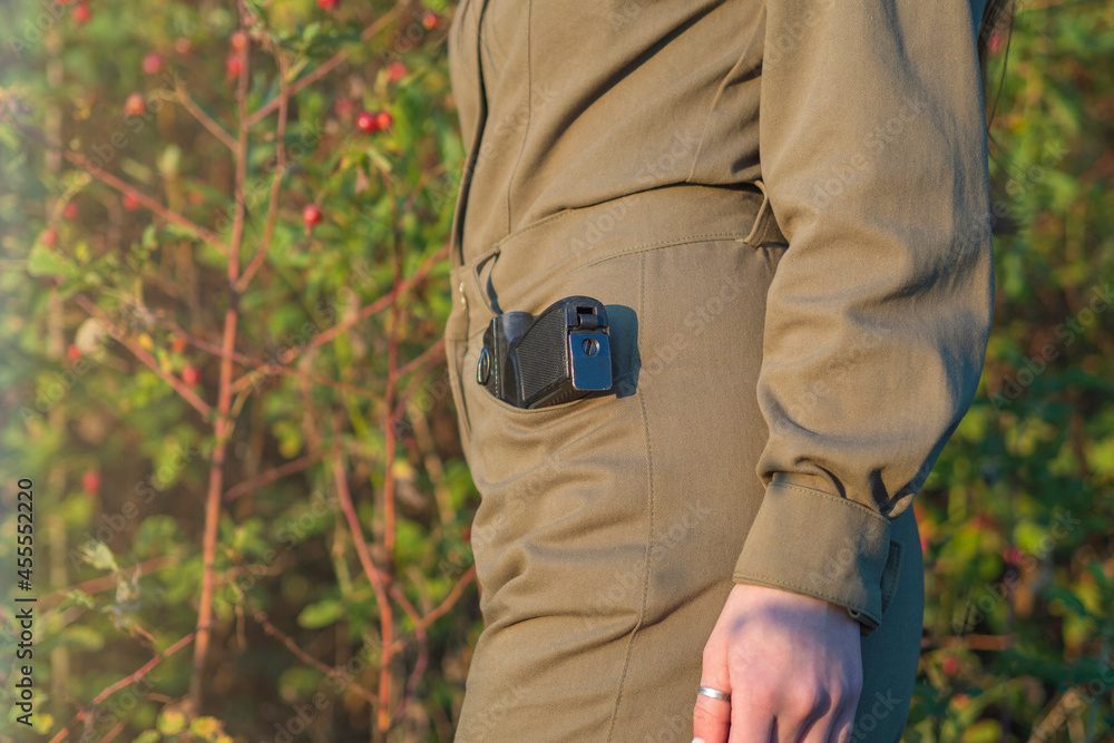 Female with a gun in a khaki uniform without a face Female with a gun in a khaki uniform without a face