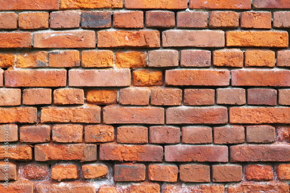 A wall of old crumbling red brick, laid horizontally. Texture for the background. A wall of old crumbling red brick, laid horizontally. Texture for the background.
