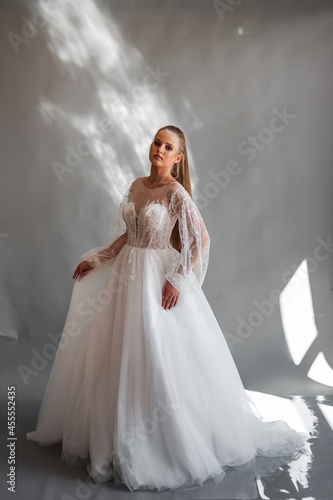 Perfect bride, portrait of a girl in a long white dress. Beautiful hair and clean delicate skin. Wedding hairstyle blonde woman. 
