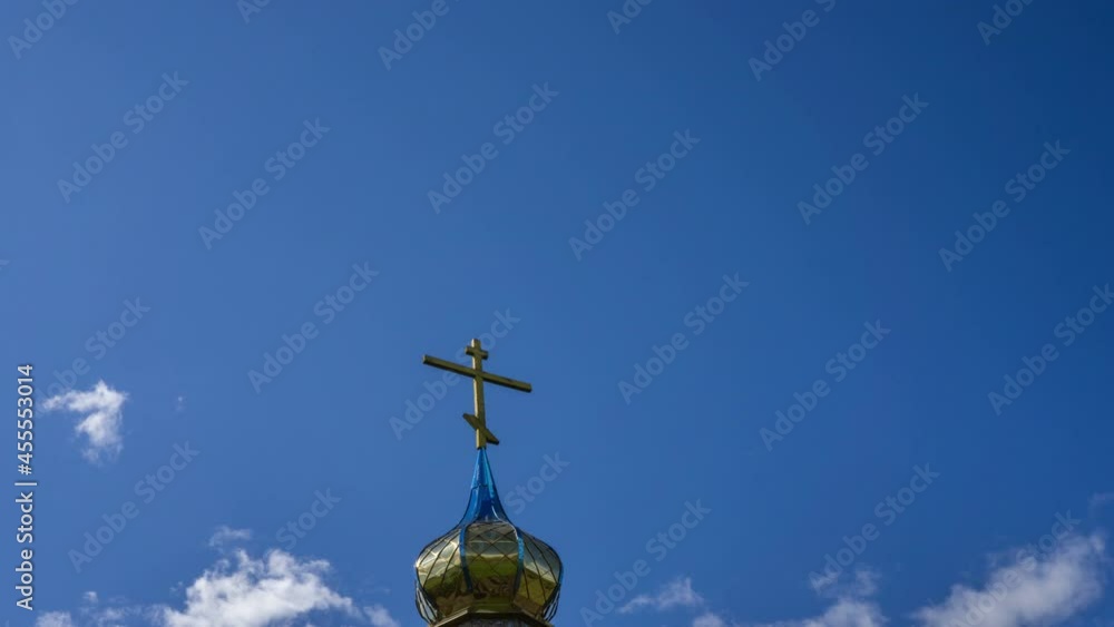 Dome with an Orthodox cross against the background of a blue sky and moving clouds. Dome with an Orthodox cross against the background of a blue sky and moving clouds.