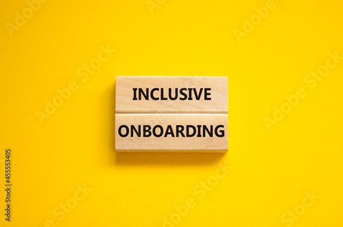 Inclusive onboarding symbol. Wooden blocks with words Inclusive onboarding on beautiful yellow background. Business, HR and inclusive onboarding concept. Copy space.