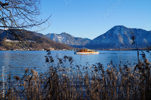 a beautiful view of lake Tegernsee and an excursion boat with the wintery Alps in the background on a sunny December day (Bavaria in Germany) 