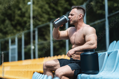 Obraz na plátně muscular athlete male drinking protein whey cocktail after exercising outdoor