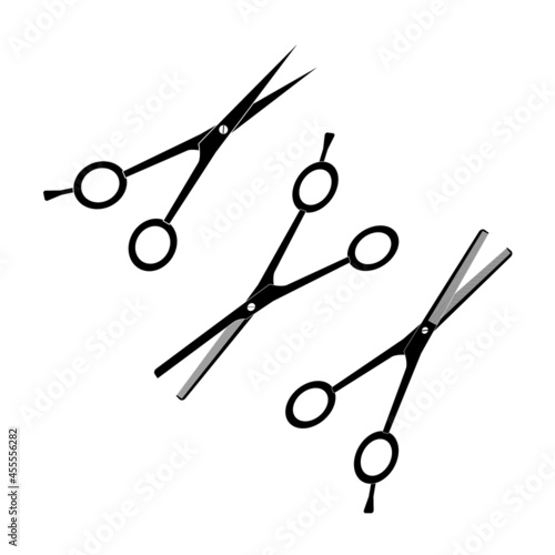 Hairdressing metal scissors of different types of black color on a white background.