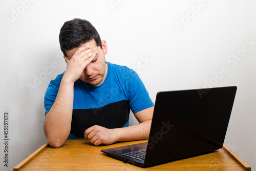 Hombre cansado frente a computadora