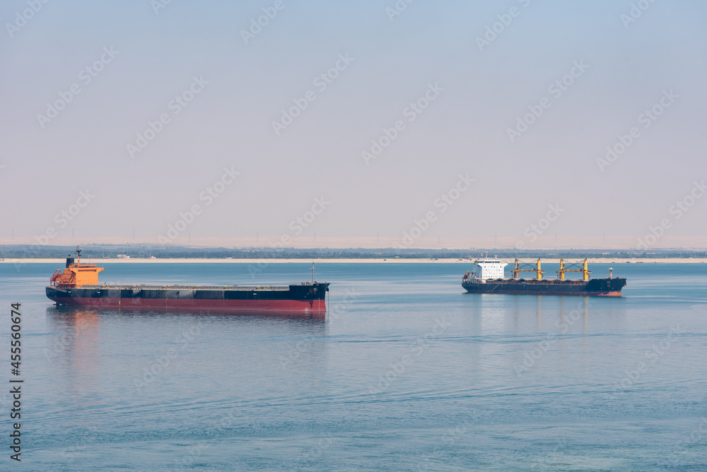 Great Bitter Lake calm waters with cargo ships during Suez Canal transit. 