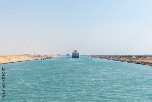 Suez Canal, panorama view of the canal with blue water and transiting ship on the horizon. 