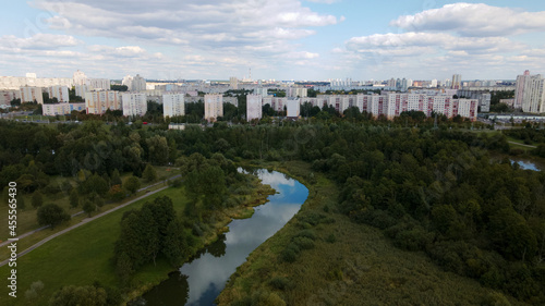 City landscape. Nearby there is a park area. Blue sky with white clouds. Aerial photography. © f2014vad