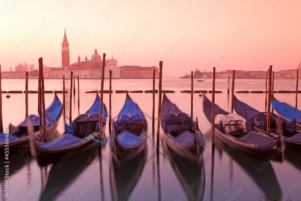 Gondolas in St. Mark's square with Saint George's island at sunrise, Venice, Italy