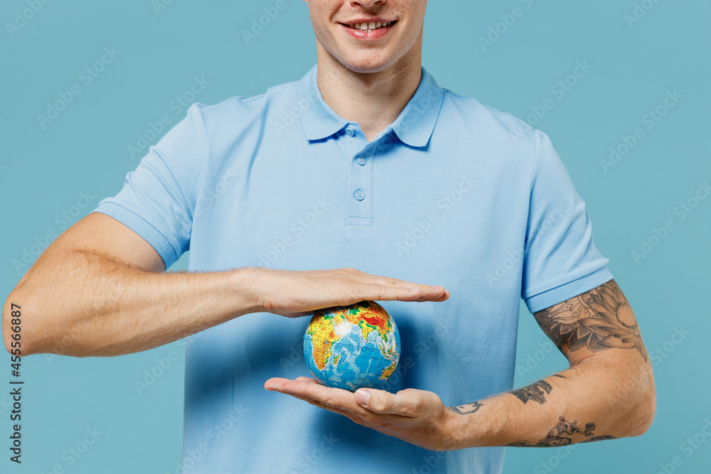 Close up cropped young curly man 20s years old wear azure t-shirt hold in palms Earth world globe isolated plain pastel light blue background studio portrait. Ecology environment protection concept Close up cropped young curly man 20s years old wear azure t-shirt hold in palms Earth world globe isolated plain pastel light blue background studio portrait. Ecology environment protection concept