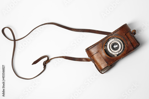 Old vintage camera with 50 mm lens in brown leather case isolated on white background