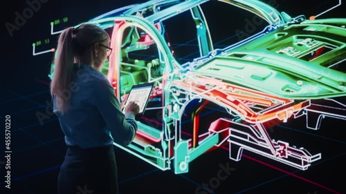 Innovative Green Energy Startup: Female Engineer Designing Electric Car Using Tablet Computer and Big Wall Screen to Analyse Prototype. Concept for Sustainable Zero Emissions Carbon Neutral Vehicle photo