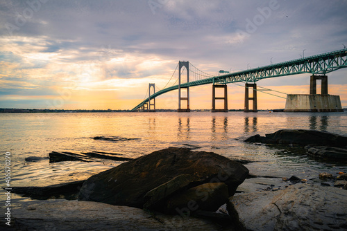 Sunrise over the whale-shaped rocks at the beach and Claiborne Pell Newport Bridge on Route 138 in Rhode Island photo