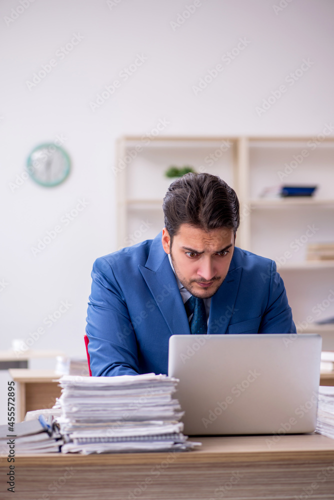 Young businessman employee and too much work in the office Young businessman employee and too much work in the office