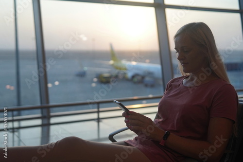 girl with a yellow suitcase sit and wait at the airport