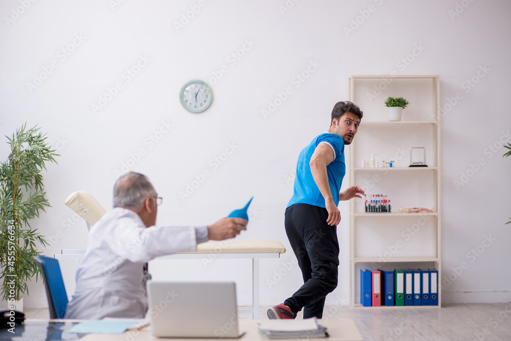 Fototapeta premium Young male patient visiting old male doctor gastroenterologist
