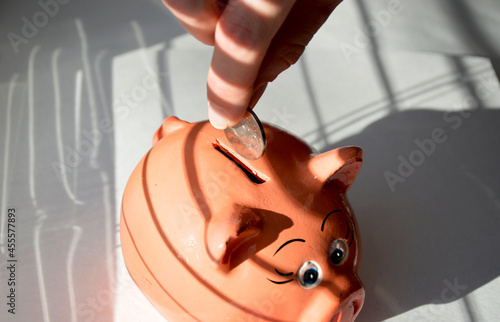 Quadro su tela a female hand puts a Russian coin into a piggy bank, a piggy bank in the shape o