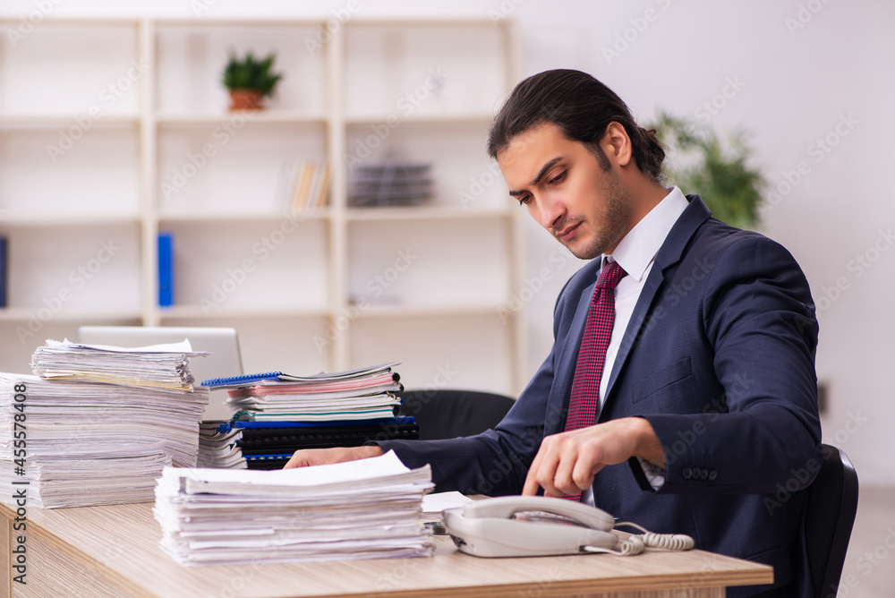 Young male employee unhappy with excessive work Young male employee unhappy with excessive work