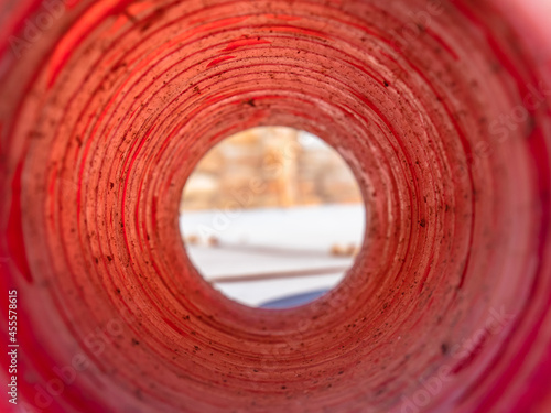 Tunnel view through a rough red construction tube showing all the circumferences forming a telescopic sight photo