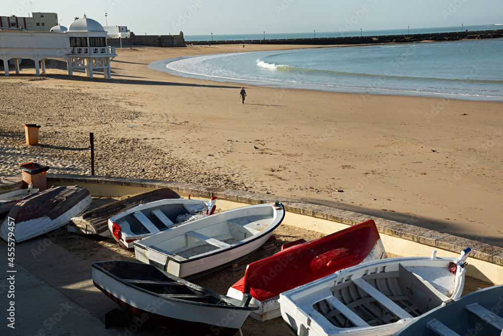 Paisaje de la playa de Cádiz con barcas de remos.
