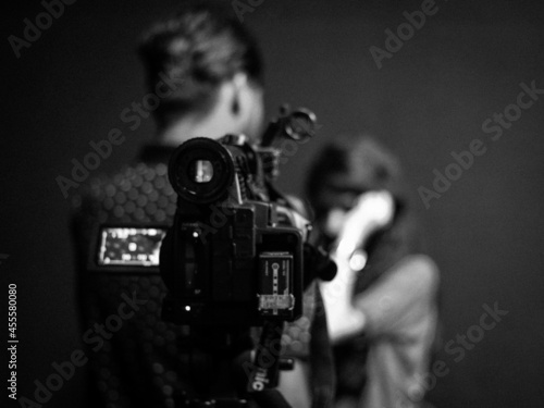 Grayscale photo of video recording man and woman