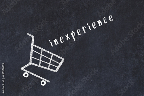 Chalk drawing of shopping cart and word inexperience on black chalboard. Concept of globalization and mass consuming