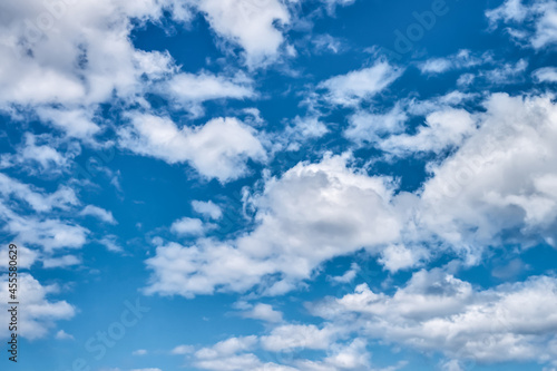 Fluffy clouds against the bright blue sky. Nature background. Copy space