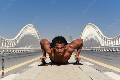 Man doing push up on bridge during daytime photo