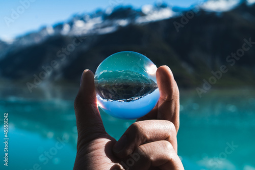 Man holding crystal ball in front of wave photo