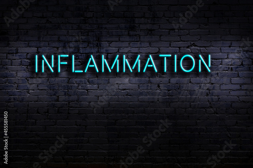 Photos Neon sign. Word inflammation against brick wall. Night view