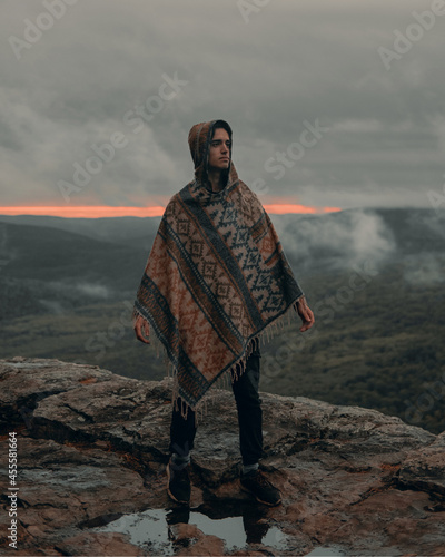 man in poncho on a background of highlands and fog photo