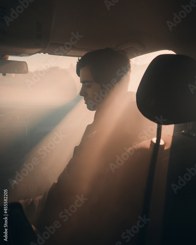 Man sitting in the front seat of car during golden hours photo