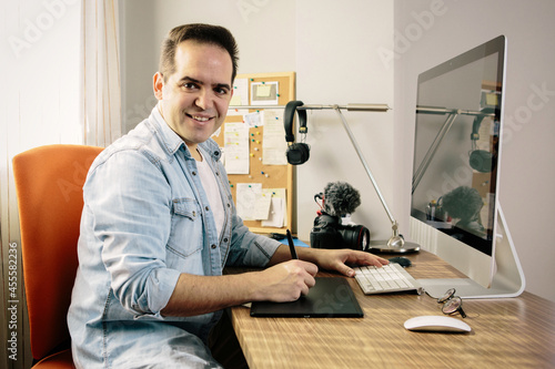 Man sitting on chair in front of laptop computer photo